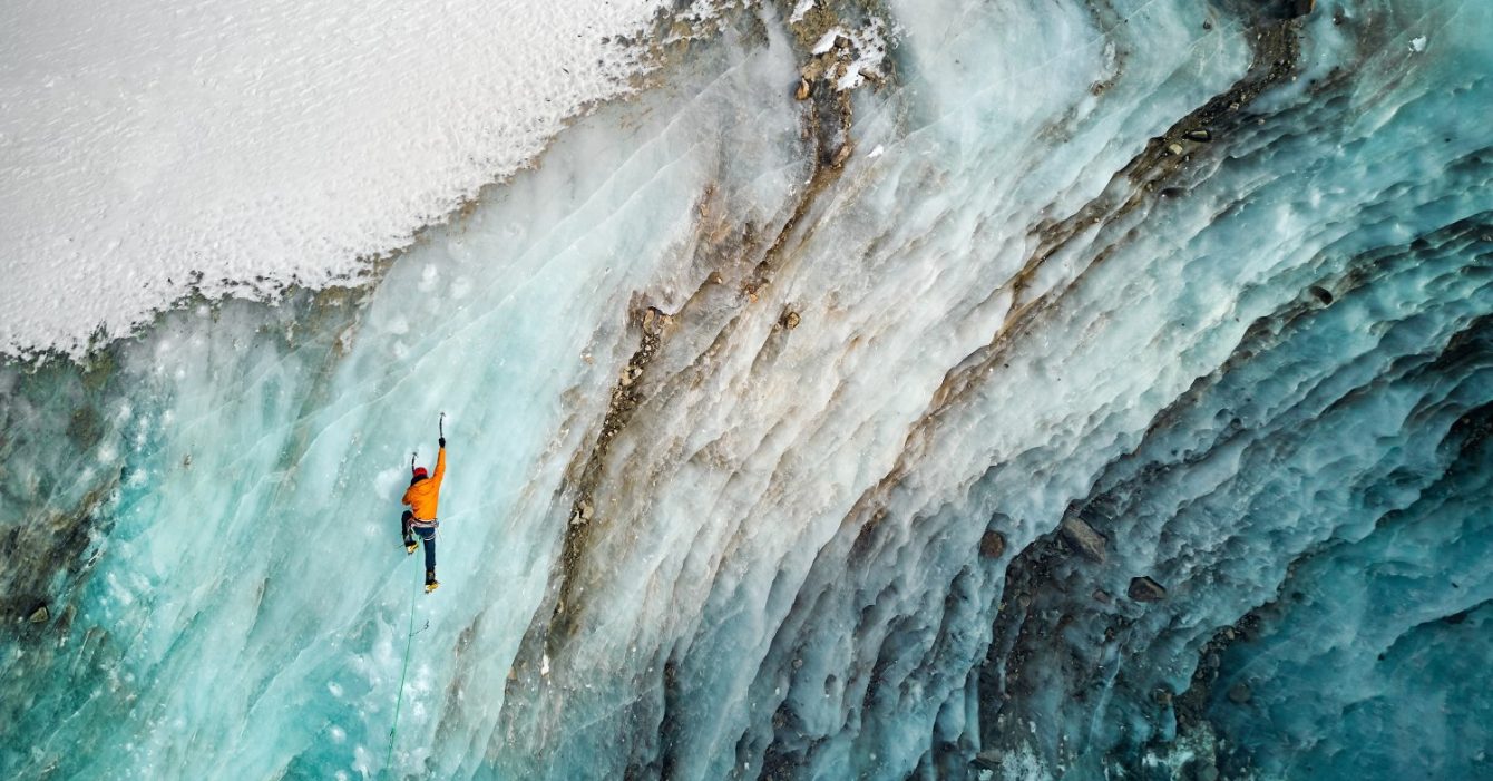 Aerial,Drone,View,Of,Athlete,In,Orange,Jacket,Ice,Climbing Aerial,Drone,View,Of,Athlete,In,Orange,Jacket,Ice,Climbing